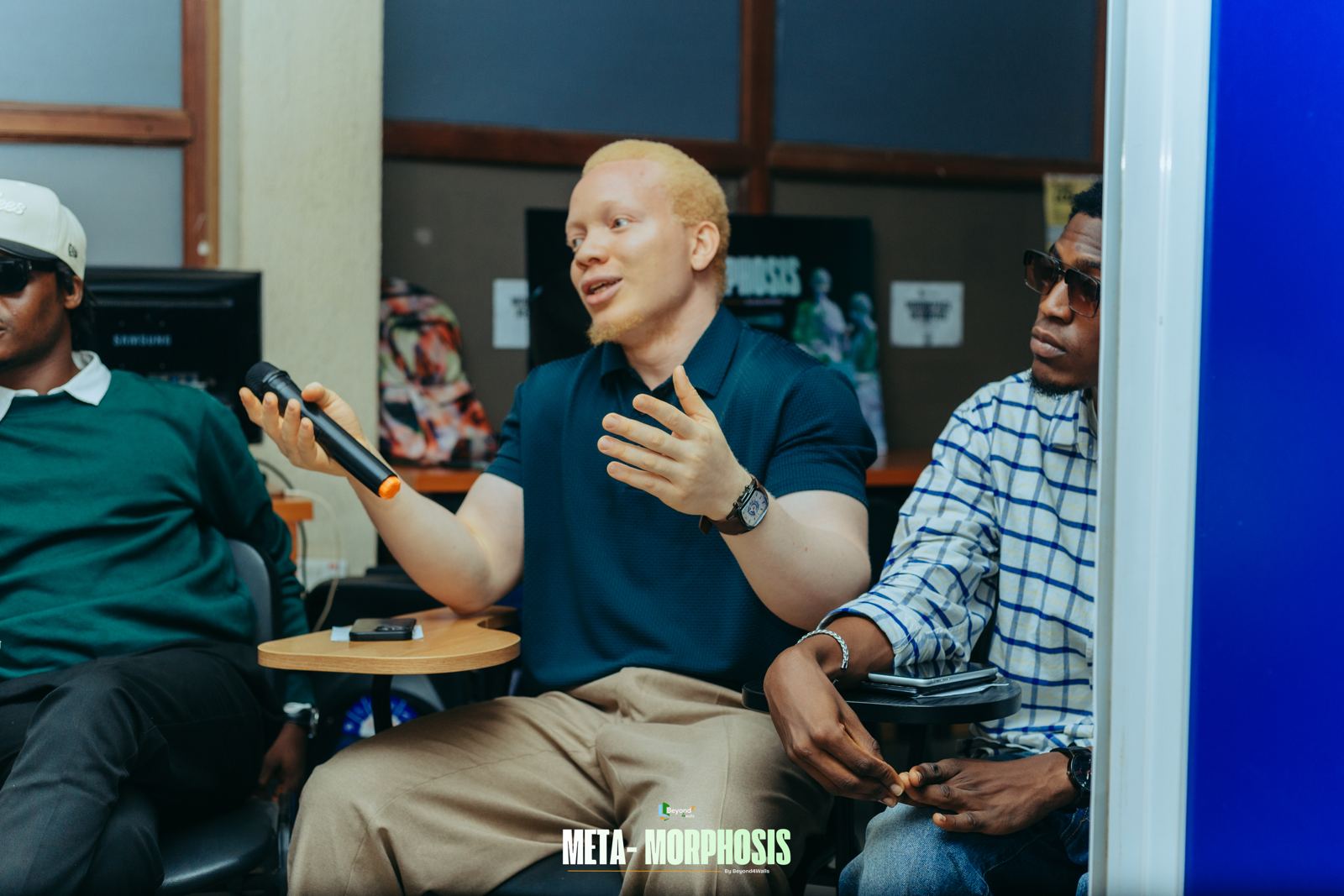 A panellist speaks into a microphone and gestures while other speakers listen
