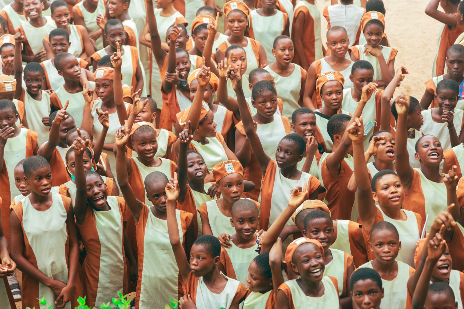 Students in the assembly cheering with their hands raised